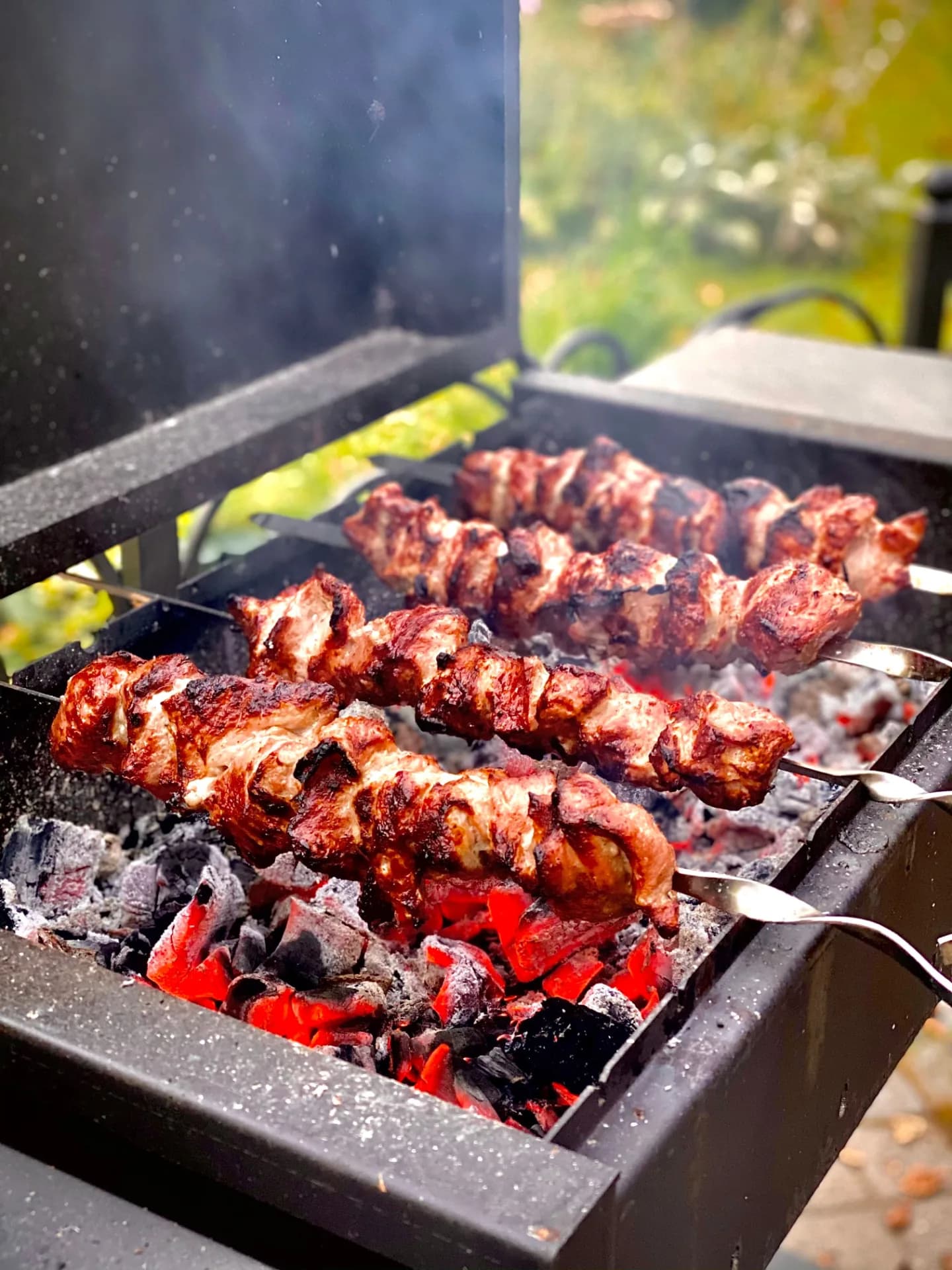 Schaschlik-Spieße über Holzkohle, leicht rauchend